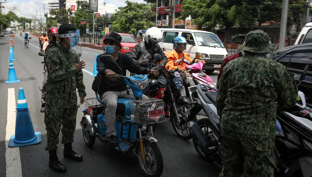 Los motoristas son parados en un puesto de control de Manila