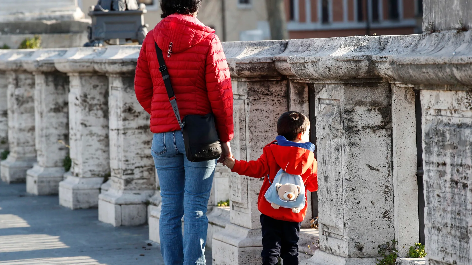 Una madre con su pequeño pasea en Roma durante el confinamiento