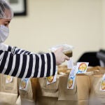 Un trabajadora voluntaria del restaurante ‘El Qüenco de Pepa’ preparan en paquetes los menús solidarios que ha elaborado la cocinera Pepa Muñoz para los más necesitados en colaboración con la ONG del chef José Andrés, Central World Kitchen, durante la crisis del coronavirus