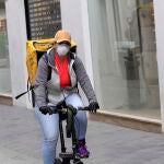 Una repartidora se protege con una mascarilla en el centro de la capital andaluza