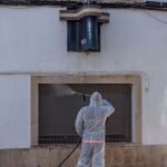 GRAF6028. MAHÓN, 05/04/2020.- Un miembro de Protección Civil desinfecta el acceso a la a la comisaría de la Policía Nacional de Mahón, hoy domingo en el inicio de la cuarta semana del estado de alarma por la pandemia del coronavirus. EFE/David Arquimbau Sintes