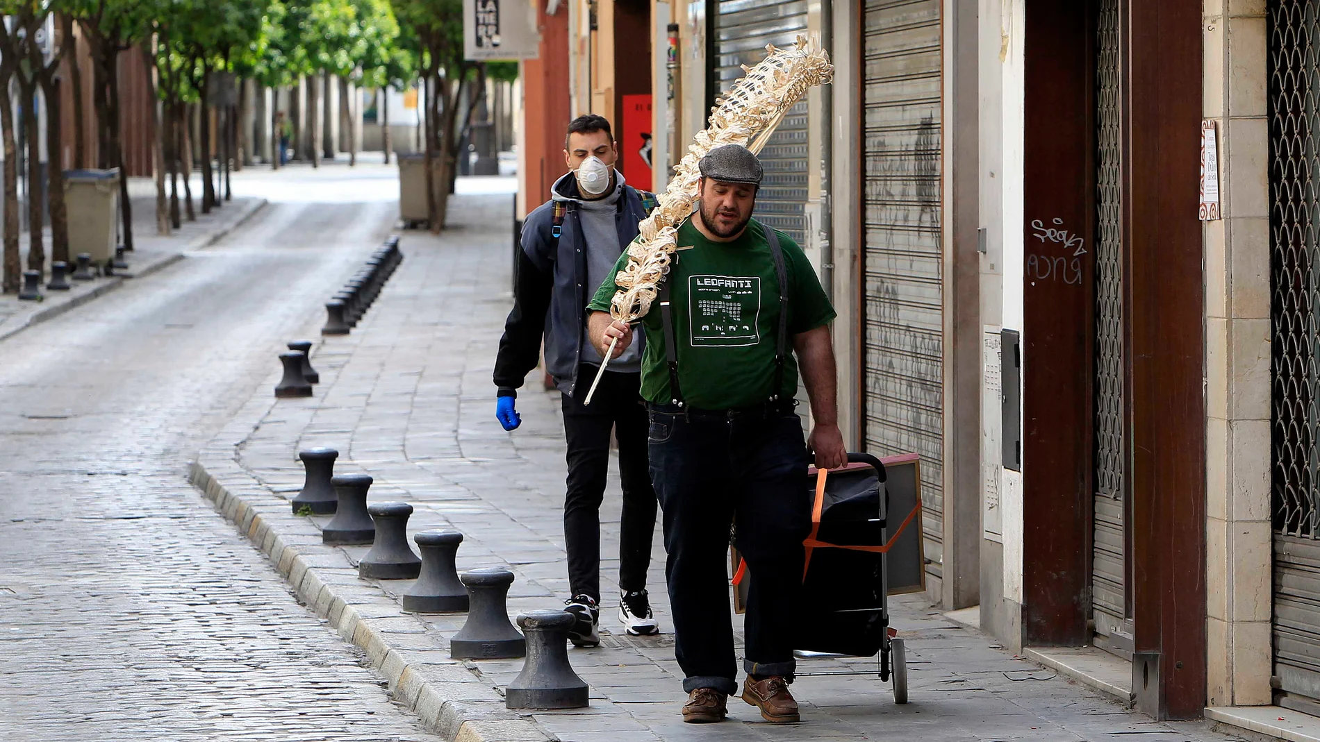 Hombres con palma por las calles de Sevilla