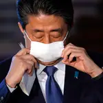 El primer ministro japonés, Shinzo Abe, se quita la mascarilla ante de iniciar la rueda de prensa en Tokio/EFE