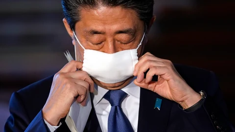 El primer ministro japonés, Shinzo Abe, se quita la mascarilla ante de iniciar la rueda de prensa en Tokio/EFE
