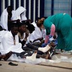 Varios inmigrantes son atendidos por los servicios sanitarios tras conseguir saltar la valla. EFE/F.G. Guerrero