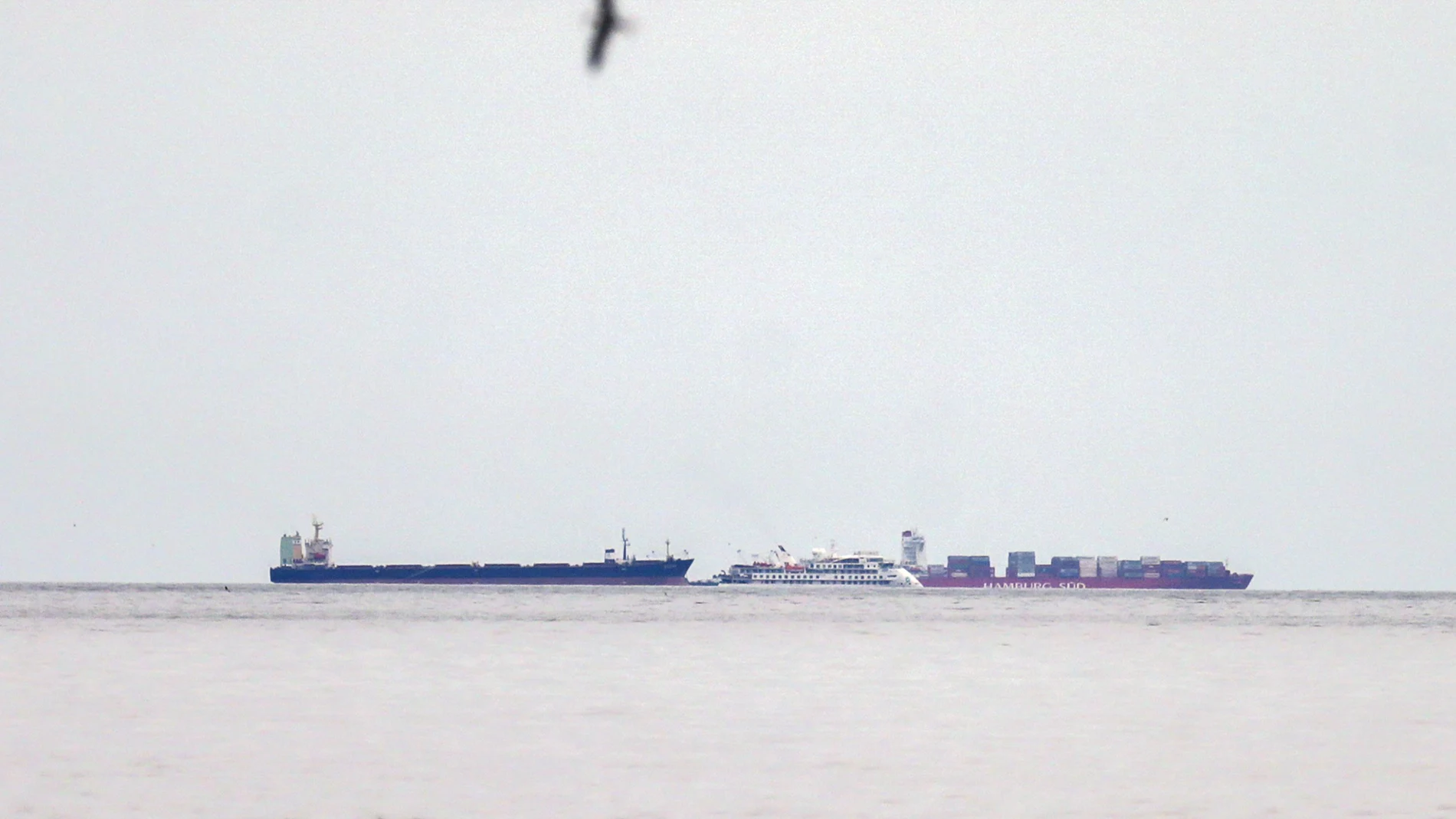 El crucero australiano "Greg Mortimer", junto a dos cargueros en el puerto de Montevideo (Uruguay)/AP