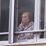 Una mujer mira preocupada desde su casa durante el Estado de Alarma en Ponferrada