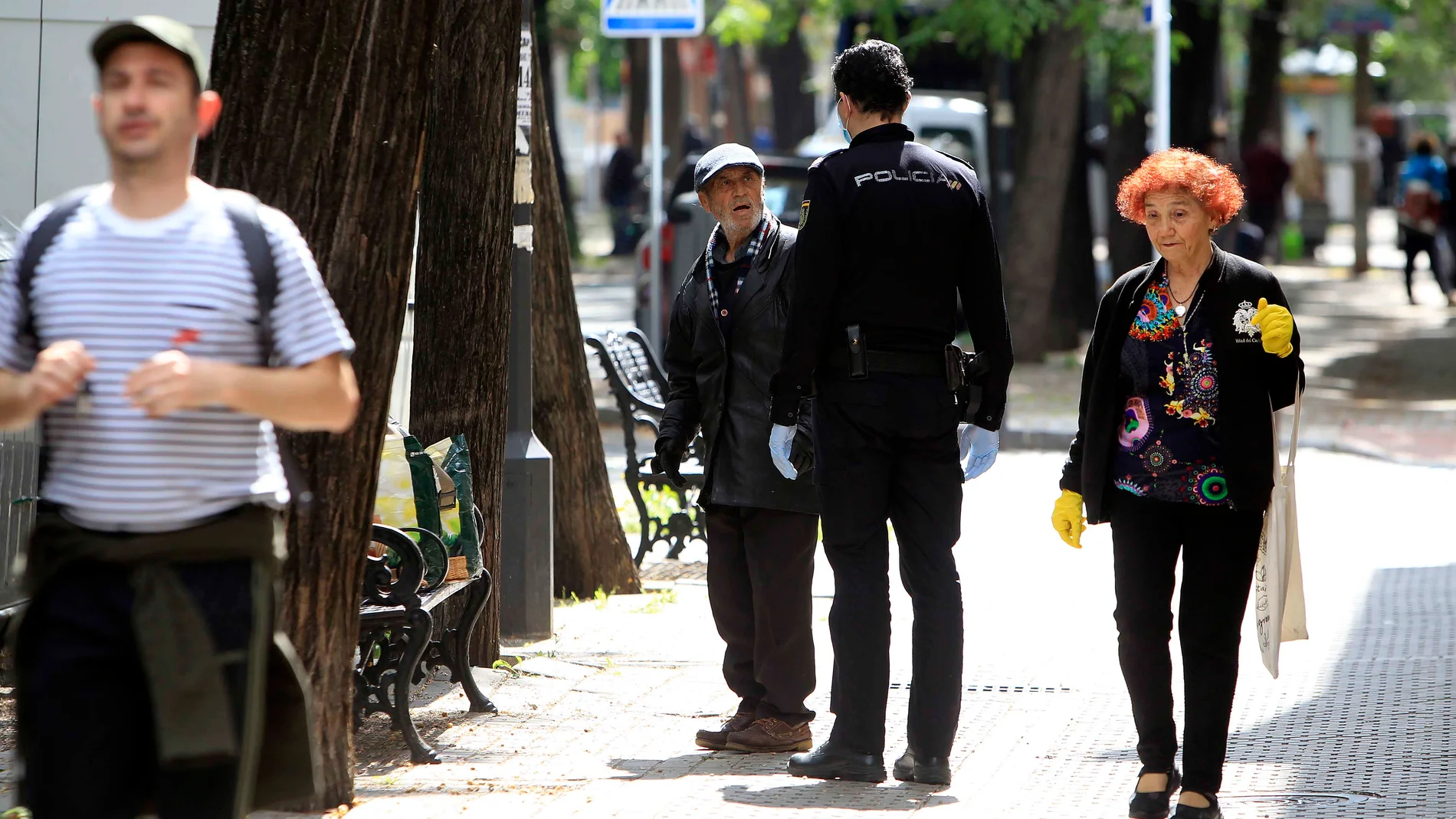 Un policía da indicaciones a un ciudadano en una calle de Sevilla