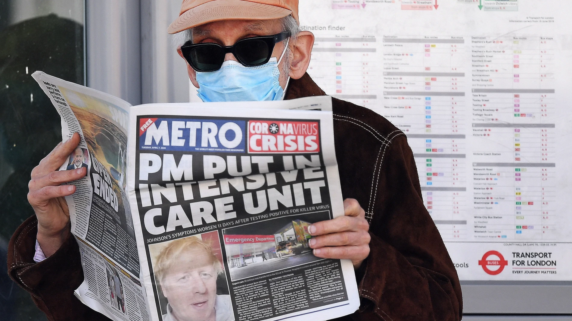 Un londinense con máscara lee el periódico con la portada dedicada a Boris Johnson