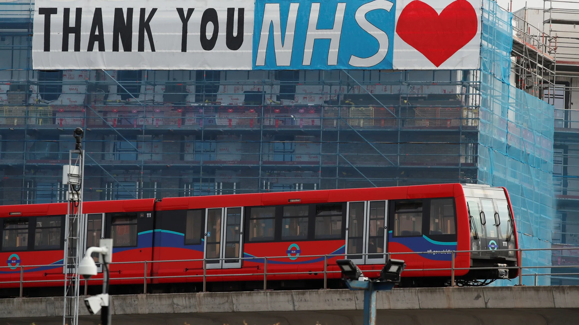 Un tren pasa junto a un cartel que da las gracias al Sistema Nacional de Salud (NHS) de Reino Unido/REUTERS