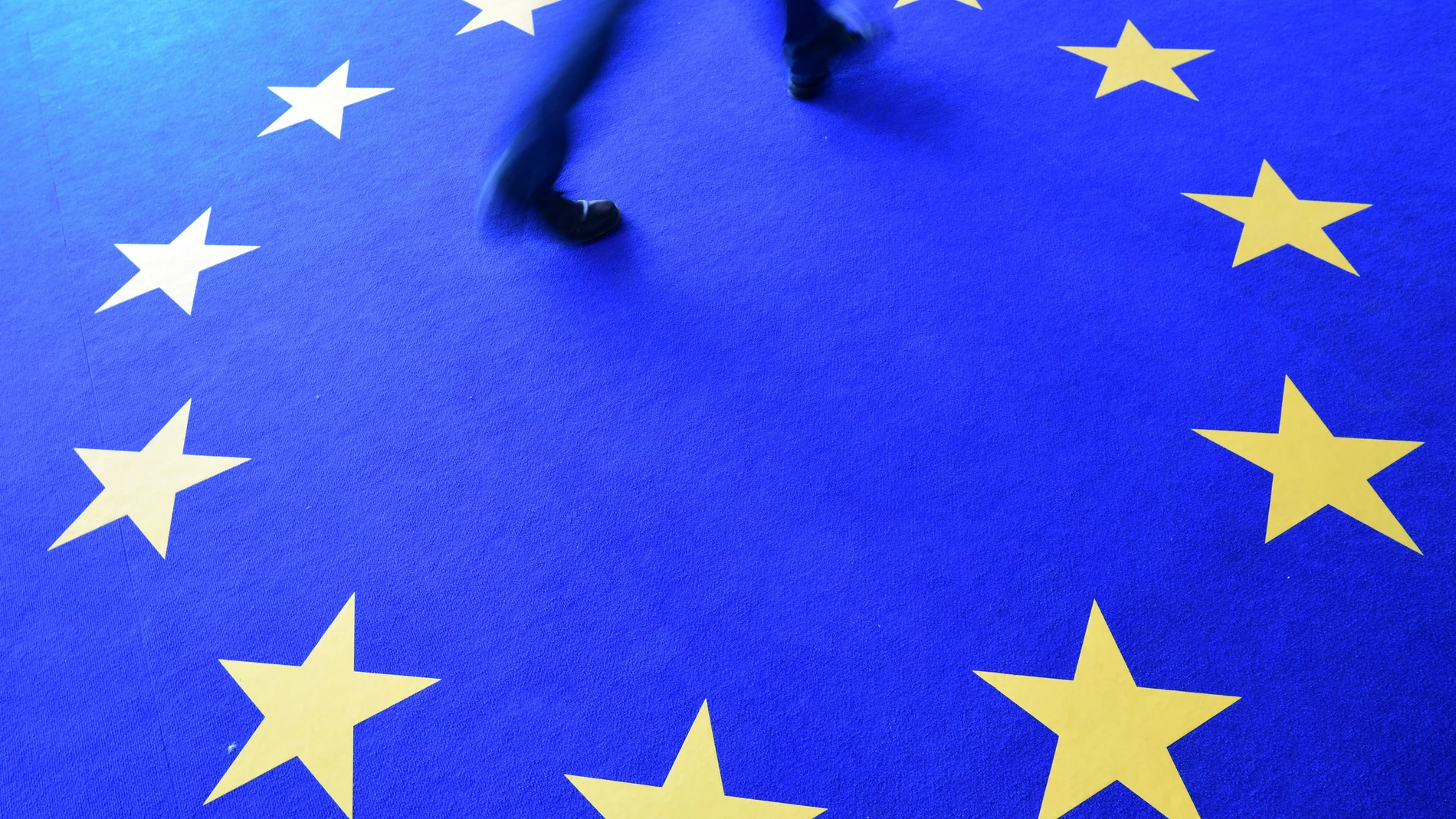 Un hombre camina en Berlín por una alfombra con el logo de Europa