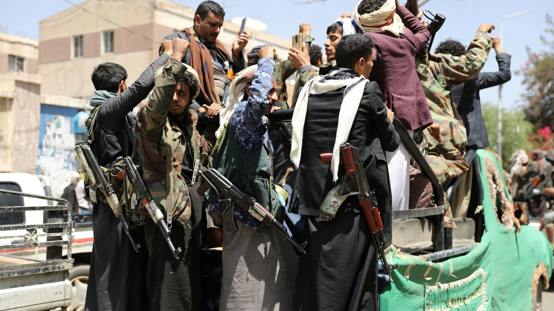 Armed Houthi followers ride on the back of a truck outside a hospital in Sanaa