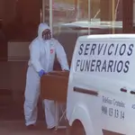 Empleados de la funeraria trasladan un féretro con los restos mortales de un anciano fallecido por Coronavirus, en la La Residencia Asistida de Segovia