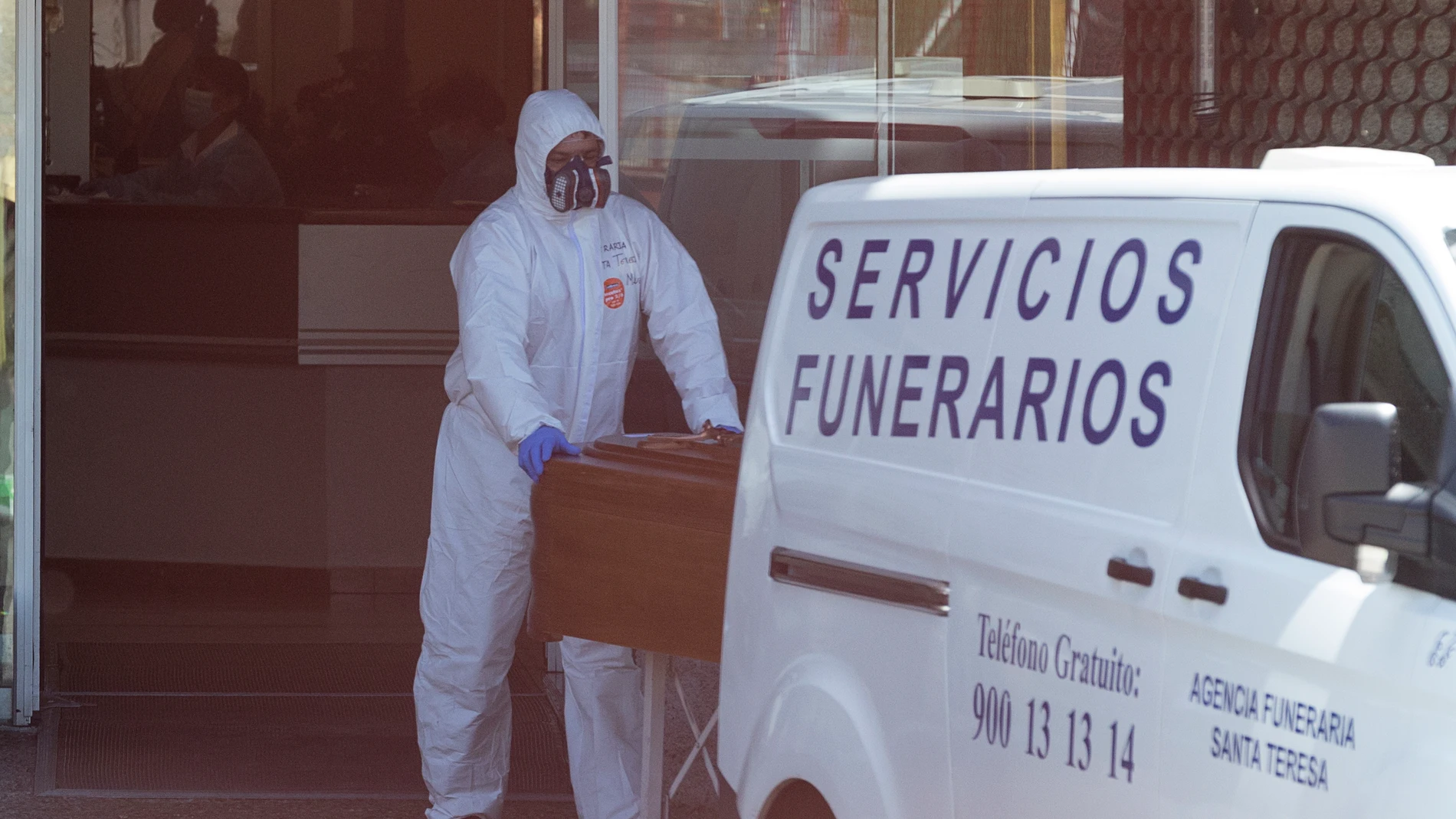 Empleados de la funeraria trasladan un féretro con los restos mortales de un anciano fallecido por Coronavirus, en la La Residencia Asistida de Segovia