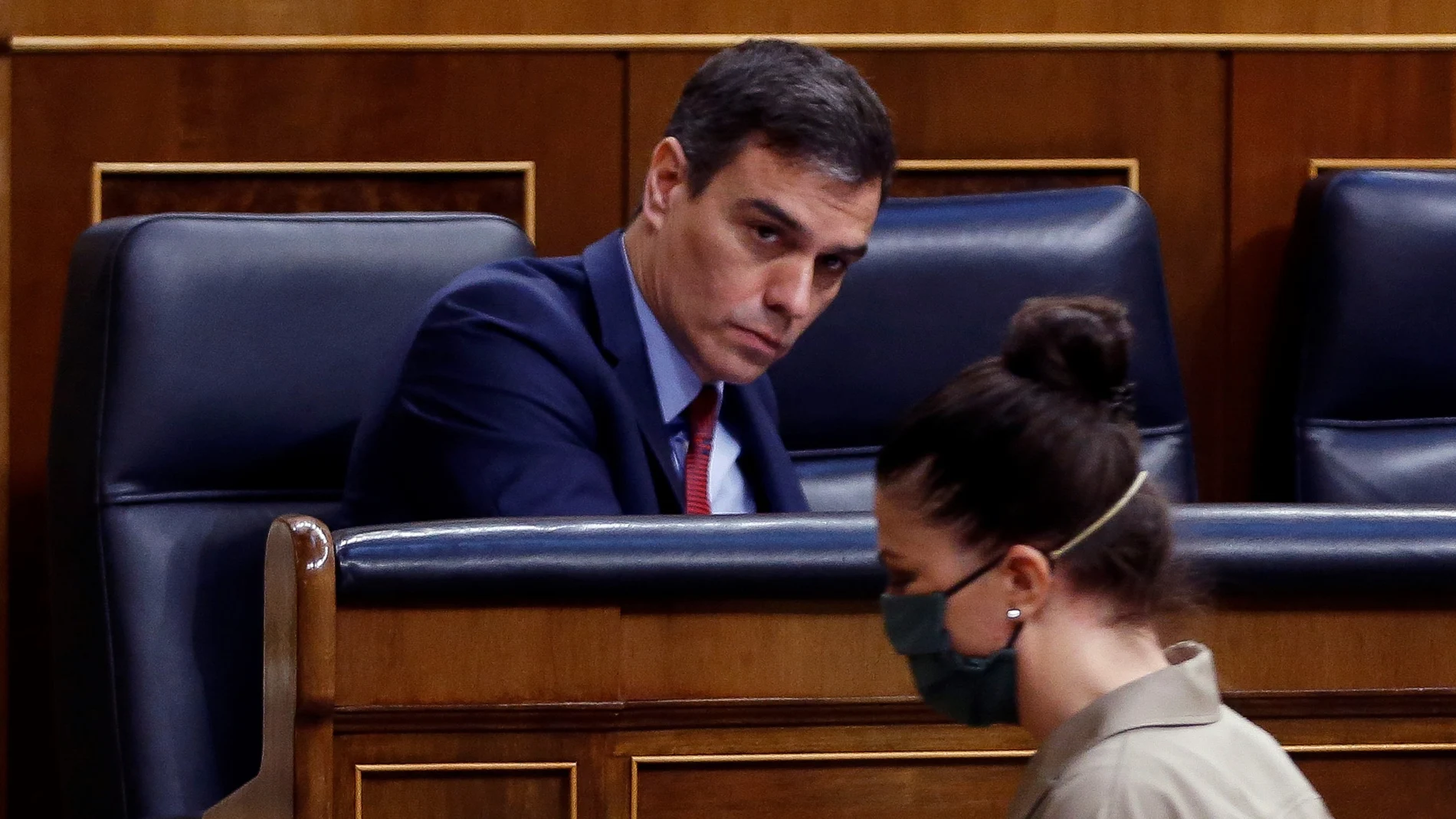 Spain's Prime Minister, Pedro Sanchez looks at far-right Vox party's deputy Macarena Olona wearing a mask to protect against coronavirus, during the opening of a parliamentary session in Madrid, Spain, Thursday, April 9, 2020. Sanchez acknowledged that Spain's government, and its regions which administer health services, were caught off guard by the crisis and left its hospitals woefully short on critical supplies, including virus tests and protective clothing for medical workers. (Mariscal, Pool Photo via AP)
