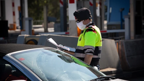Un agente de los Mossos d'Esquadra protegido con una mascarilla en un control en el peaje de La Roca del Vallès pide a un conductor el justificante que le permite su salida de casa durante un Jueves Santo atípico en el que prosigue el estado de alarma decretado por el Gobierno para la lucha contra el coronavirus, en La Roca del Vallès/Barcelona/Catalunya (España) a 9 de abril de 2020.09 ABRIL 2020 COVID-19;PANDEMIA;CORONAVIRUS;COCHES;POLICÍA;TRÁFICO;ENFERMEDAD;CONFINAMIENTODavid Zorrakino / Europa Press09/04/2020