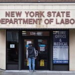 Una persona lee un cartel en la puerta de la oficina del Departamento de Empleo de Nueva York/EFE