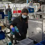 Una operaria trabaja en una cadena de producción y montaje