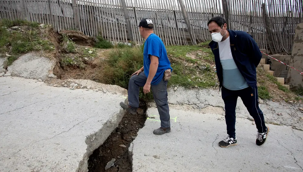 Dos hombres evalúan los daños tras un corrimiento de tierra en un cerro en el paraje conocido como el Espinar, en Granada