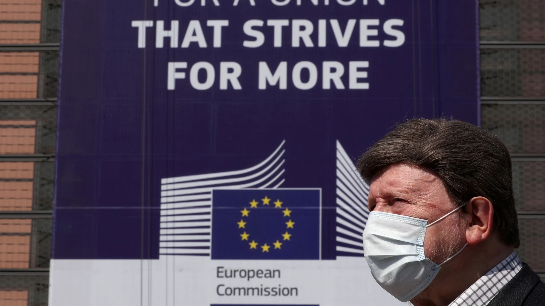 Un hombre con mascarilla pasa frente la Comisión Europea en Bruselas
