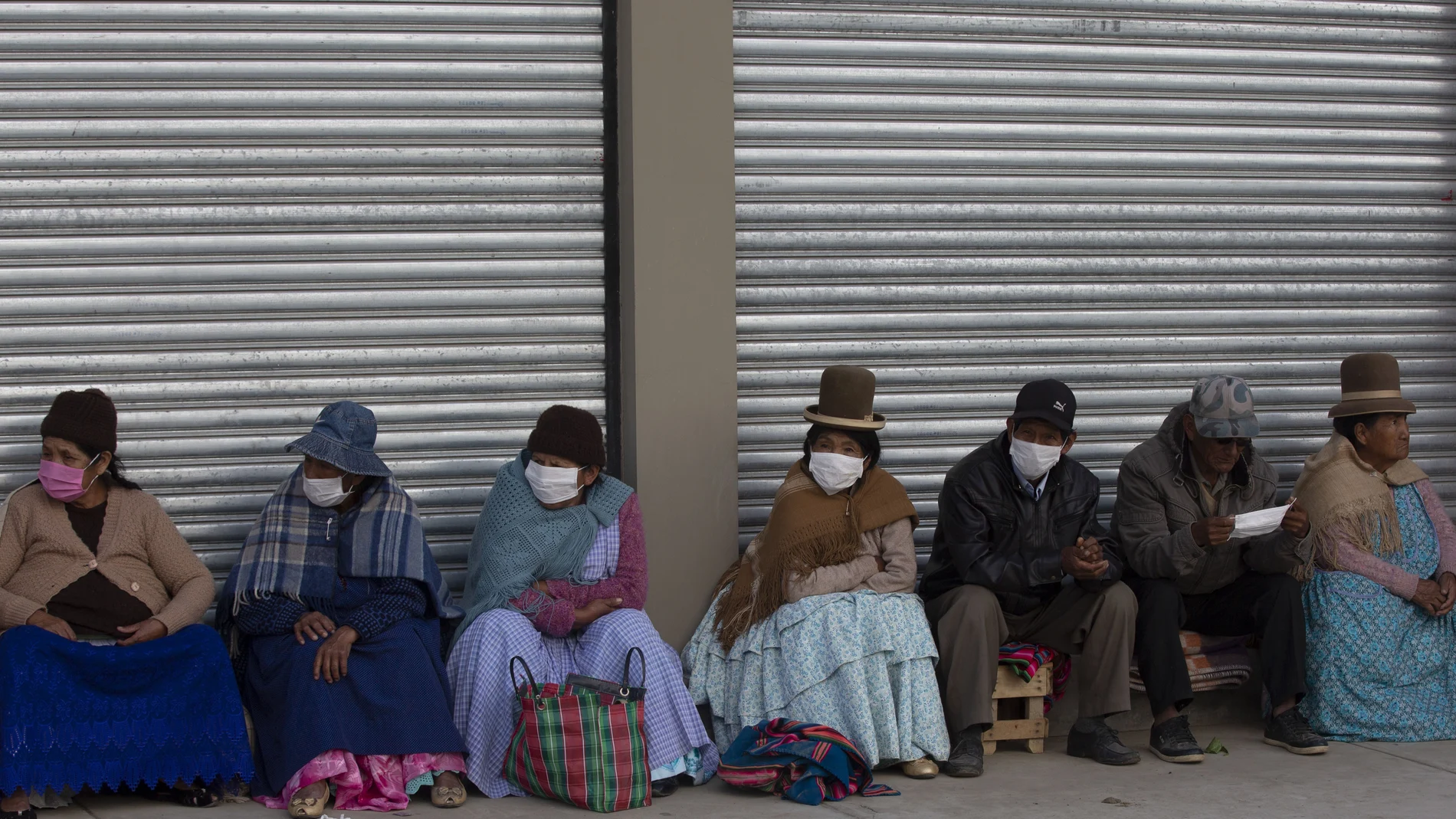 Ancianos bolivianos esperan con mascarillas para recibir su pensión en La Paz/AP