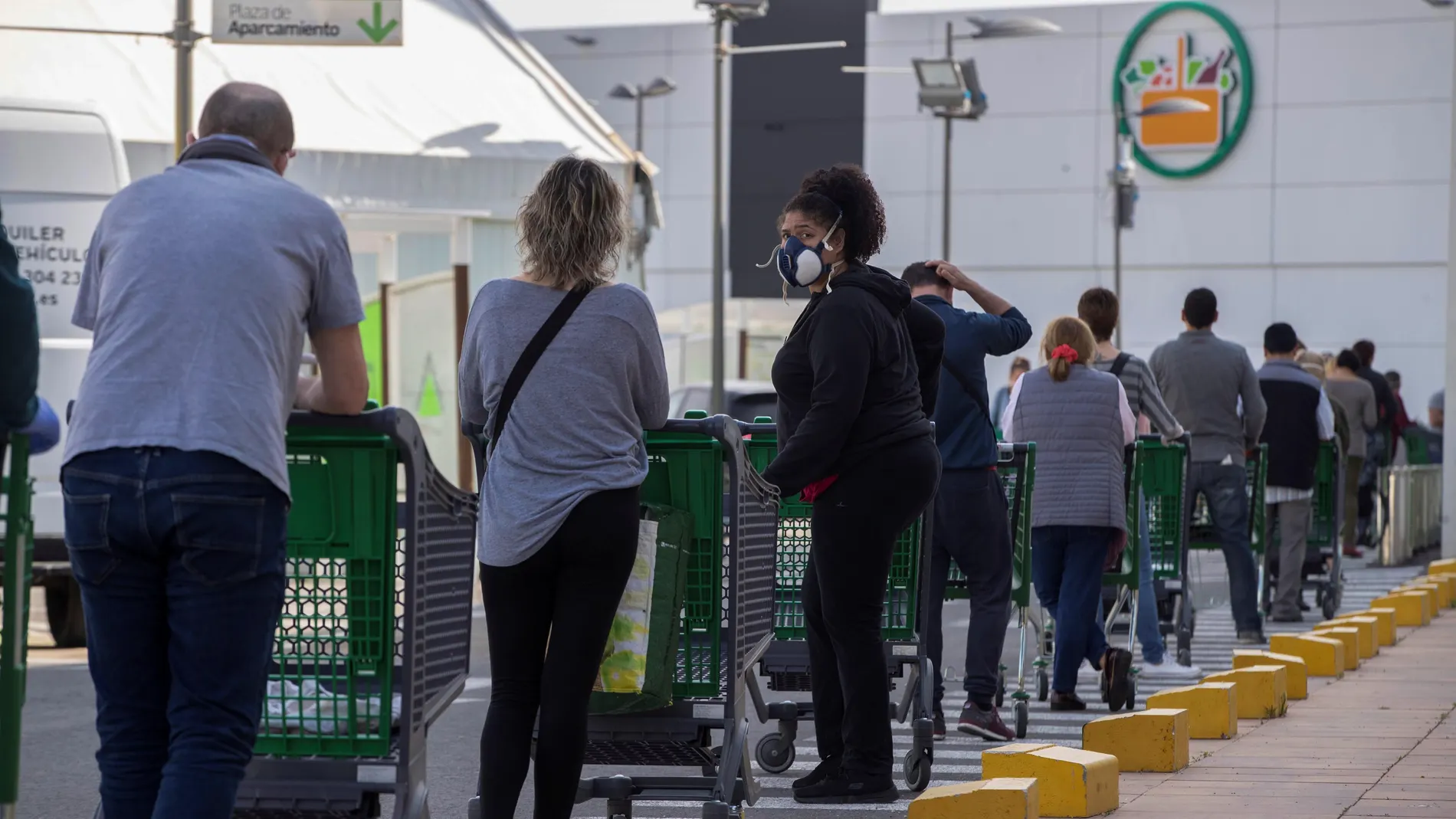 Decenas de personas guardan la distancia de seguridad en la cola para entrar a comprar a un supermercado de Murcia