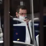 Un hombre observa su teléfono móvil en el interior de un autobús