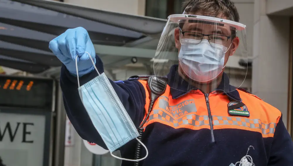Un miembro de Protección Civil durante el reparto de mascarillas para usuarios de transporte público en Málaga