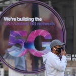London (United Kingdom), 14/04/2020.- A man in a mask passes a 5G advertisement in London, Britain, 14 April 2020. A number of social media accounts are creating conspiracy theories about links between 5G technology and coronavirus. Countries around the world are taking increased measures to stem the widespread of the SARS-CoV-2 coronavirus which causes the Covid-19 disease. (Reino Unido, Londres) EFE/EPA/NEIL HALL