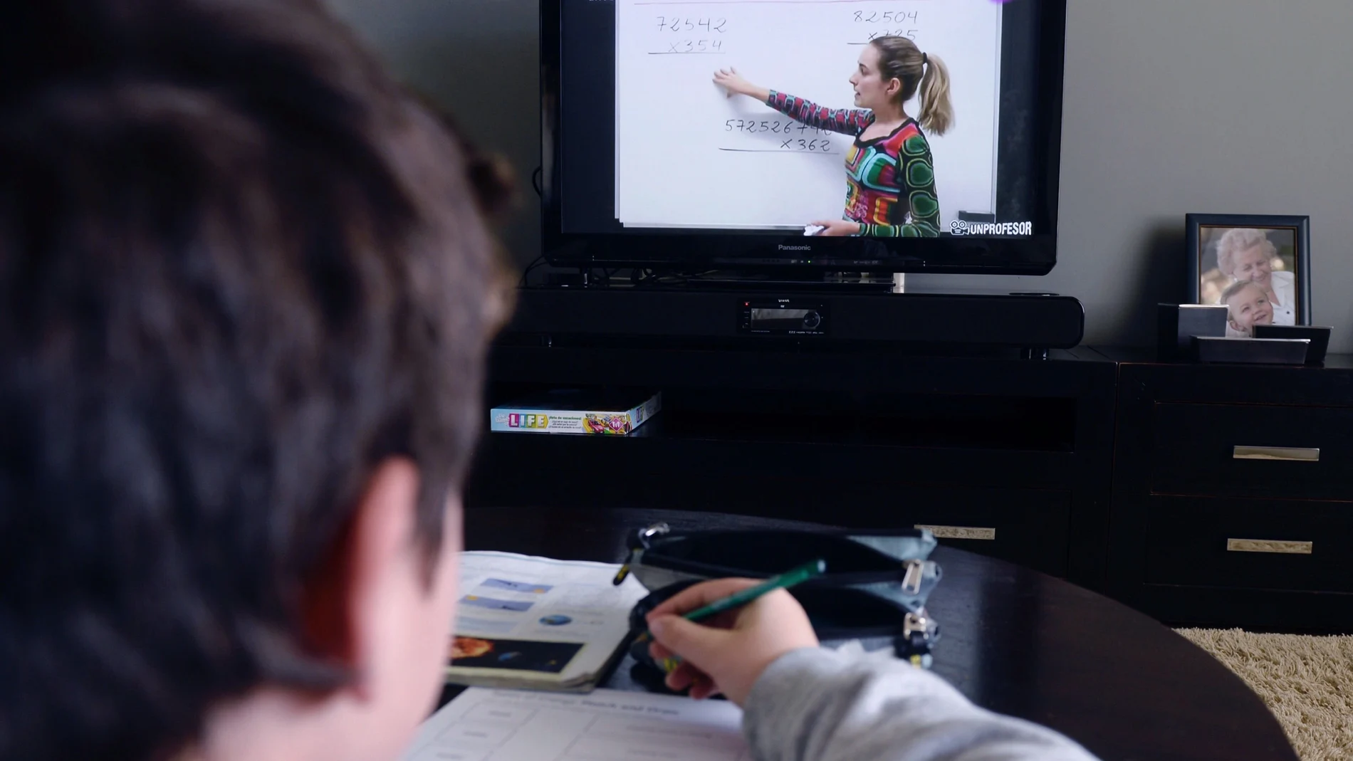 Un niño sigue desde el televisor de su casa, la programación educativa del canal CLAN de RTVE