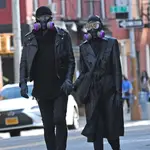 Una pareja camina parapetada en el East Village