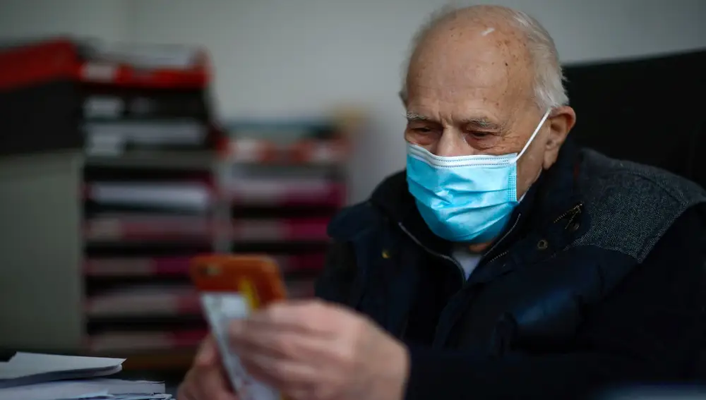 Christian Chenay atiende por el móvil a uno de sus pacientes desde su consulta, aunque está cerrada al público, en un suburbio de París