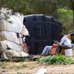 Un grupo de inmigrantes a las puertas de una chabola, en un asentamiento de Moguer