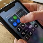 Una usuaria de iPhone activa la opción de Bluetooth en su teléfono
