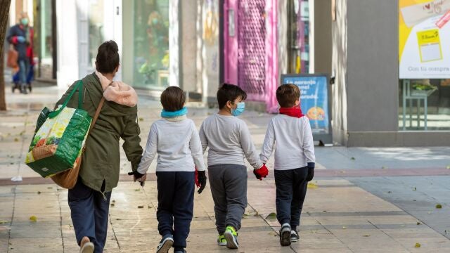 Una madre y sus hijos tras hacer la compra en Zaragoza