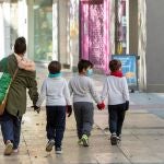 Una madre y sus hijos tras hacer la compra en Zaragoza