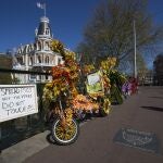 Un cartel en una calle de Ámsterdam recomienda sacar fotos, pero no tocar, las bicicletas decoradas con flores para no contagiarse de coronavirus