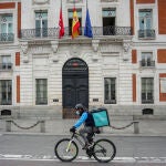 Un "rider" de Deliveroo circula por la Puerta del Sol, en Madrid