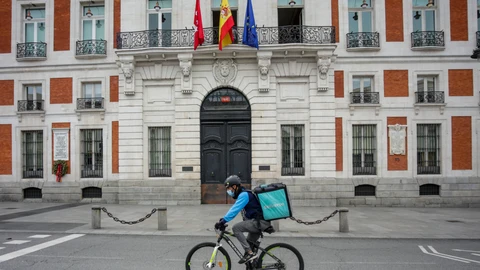 Un "rider" de Deliveroo circula por la Puerta del Sol, en Madrid