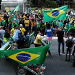 19 April 2020, Brazil, Sao Paulo: Supporters of Brazilian President Jair Bolsonaro hold flags during a protest demand for the reopening of trade and against the National Congress and the government of Sao Paulo, which extended the quarantine in the state to delay the spread of the new coronavirus. Photo: Dario Oliveira/ZUMA Wire/dpa19/04/2020 ONLY FOR USE IN SPAIN