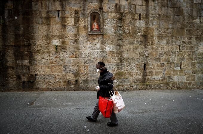 Una mujer pasa por delante de la hornacina de San Fermín en la cuesta de Santo Domingo de Pamplona, tras conocerse la suspensión de las fiestas de 2020