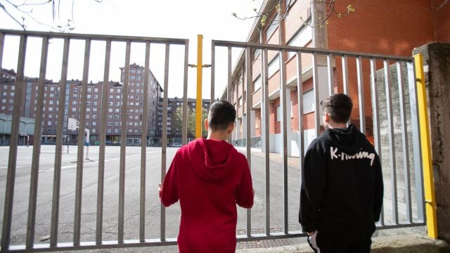 Dos adolescentes en la puerta del colegio