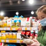 Imagen de una mujer con mascarilla en un supermercado
