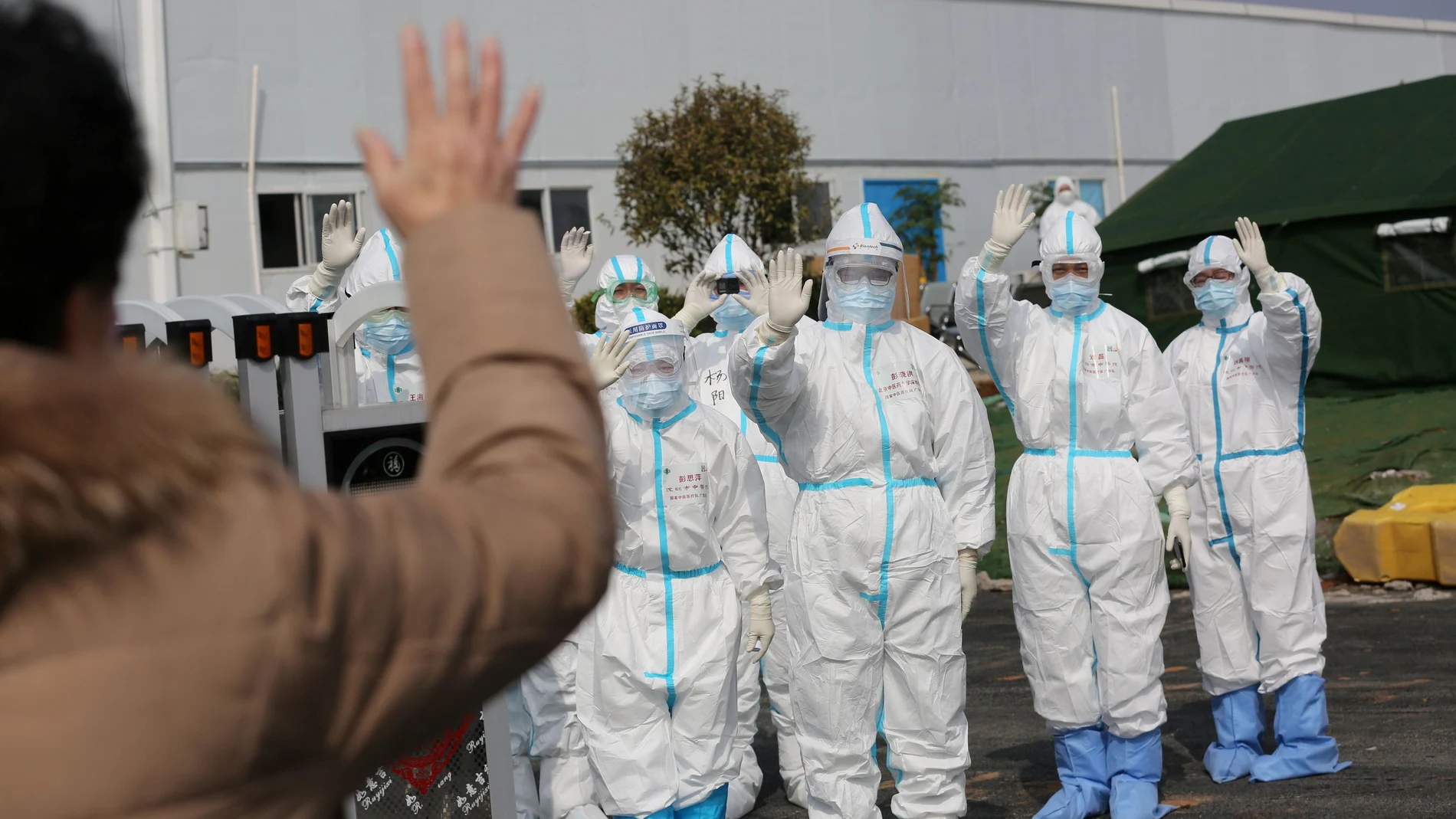 FILE PHOTO: Medical personnel in protective suits wave hands to a patient who is discharged from the Leishenshan Hospital after recovering from the novel coronavirus, in Wuhan