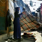 Una refugiada siria, madre de cinco hijos, tiende una manta en el campo de refugiados de Abu Fares, en el Valle de la Bekaa