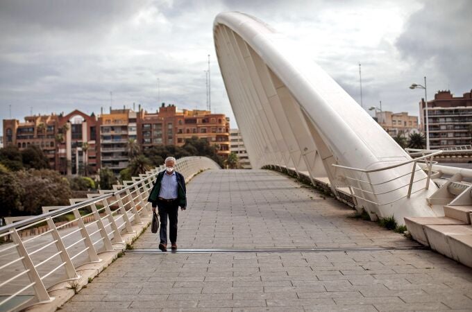 Una persona con mascarilla camina hoy por el puente de la Exposición de Valencia, el día que se cumplen los cuarenta días de confinamiento debido a la pandemia provocada por el coronavirus