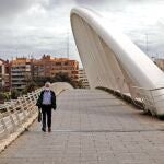 Una persona con mascarilla camina hoy por el puente de la Exposición de Valencia, el día que se cumplen los cuarenta días de confinamiento debido a la pandemia provocada por el coronavirus
