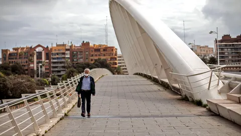 Una persona con mascarilla camina hoy por el puente de la Exposición de Valencia, el día que se cumplen los cuarenta días de confinamiento debido a la pandemia provocada por el coronavirus