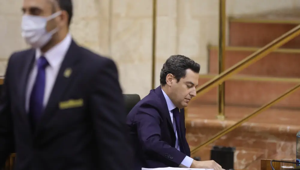 El presidente de la Junta de Andalucía, Juanma Moreno (1d), durante la sesión presencial de la Diputación Permanente del Parlamento de Andalucía, donde comparecerá para valorar la evolución de la pandemia por coronavirus en Andalucía.