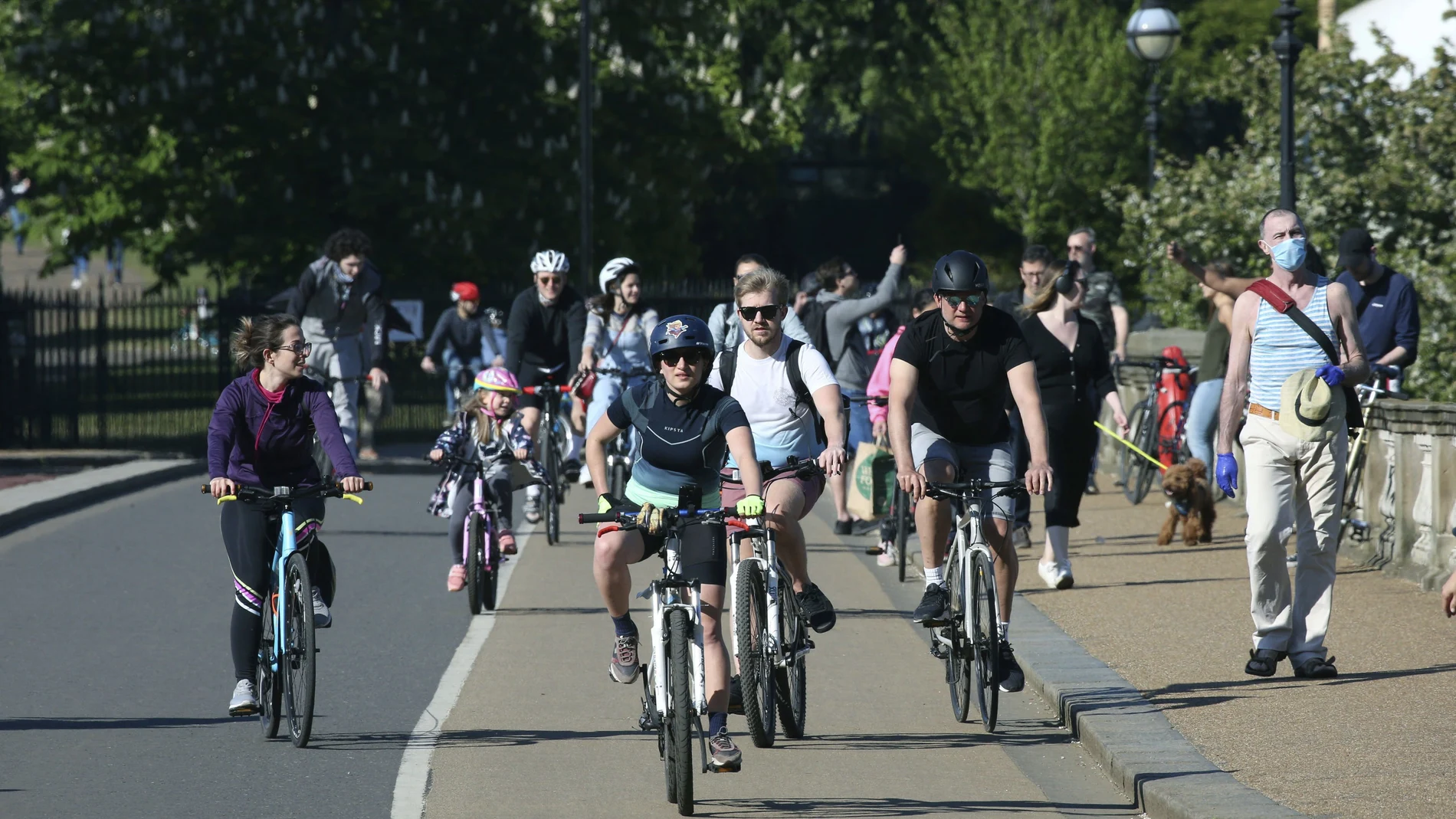 Familias con bicis cruzan el puente de Serpentine en Hyde Park en Londres, el confinamiento en Reino Unido permite una salida diaria con niños para hacer deporte